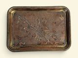 a metal tray with a design on it on a white surface