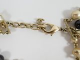a close up of a necklace with pearls and charms on it
