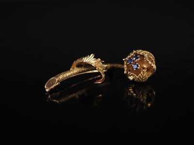 une paire de boucles d'oreilles en or ornées de pierres bleues sur un fond noir