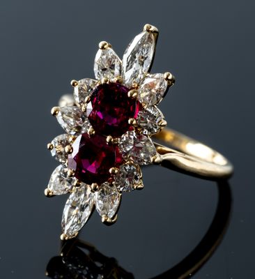 a close up of a red and white diamond ring on a black surface