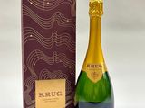 the bottle of champagne is next to the box of wine