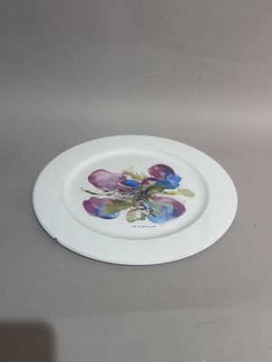 a white plate with purple flowers on it on a table