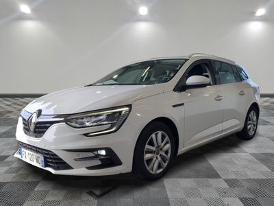 a white car is parked on a checkered floor in a garage