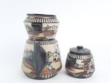 two vases sitting next to each other on a white surface