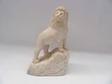 statue d'un lion posé sur un rocher, sur fond blanc