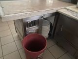 a red bucket sitting in the middle of a kitchen