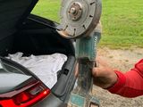 un homme qui range quelque chose dans le coffre d'une voiture