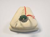 a small white bag with a green broocher on it