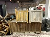 two wooden beds in the middle of a pile of crates