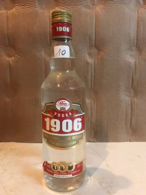 a bottle of liquor sitting on a table next to a wall
