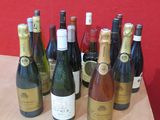 Des bouteilles de vin sont alignées sur une table devant un mur rouge
