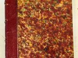 un vieux livre à la couverture rouge posé sur une table