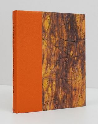a book with orange cover sitting on top of a white table
