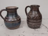 two vases sitting on a table next to each other