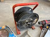 a reel and a drillet on the floor in a garage
