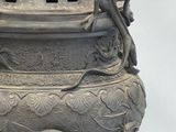 a large metal pot with a dragon on it