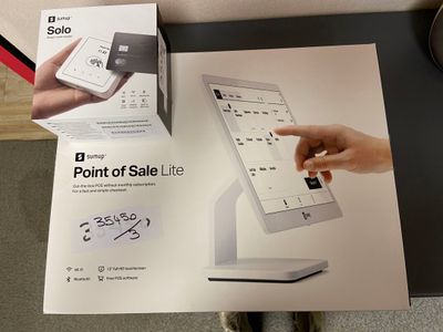 someone is holding a smart phone in front of a box