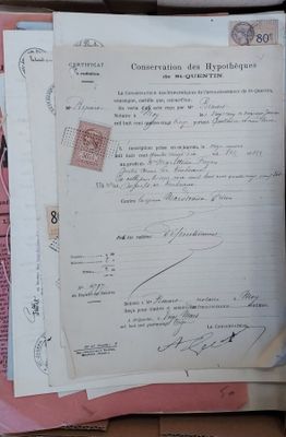 une pile de papiers et une paire de ciseaux posés sur une table