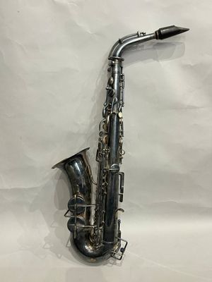 a silver saxophone sitting on top of a white sheet of paper