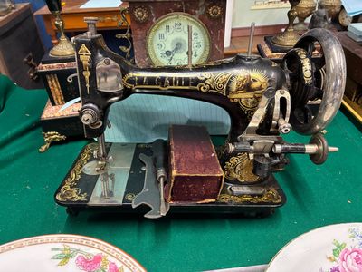 une machine à coudre posée sur une table, avec une horloge en arrière-plan