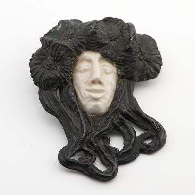une photo en noir et blanc représentant le visage d'une femme avec des fleurs dans les cheveux