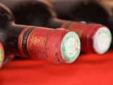 several bottles of wine are lined up on a red surface