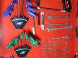 many tools hanging on a red wall in a garage