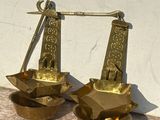 pair of antique brass scales on a table with a white wall in the background