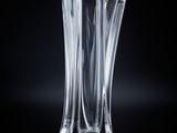 a glass vase that is sitting on a black surface