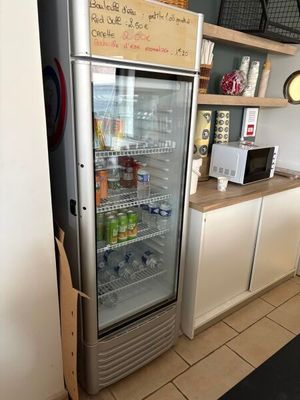 a refrigerator that is open in a kitchen with a sign on the door