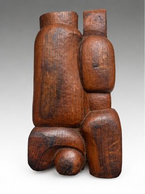 a wooden sculpture of two people sitting on top of each other