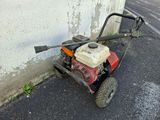 a small lawn mower parked on the side of the road