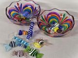 two glass bowls with candy in them sitting on a table