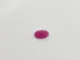a single pink stone sitting on top of a white surface