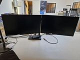 deux écrans posés sur une table, avec une lampe