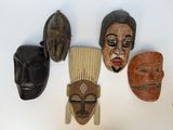 quatre masques accrochés au mur d'une pièce
