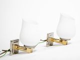 two white glass lamps on a metal stand with a green cord