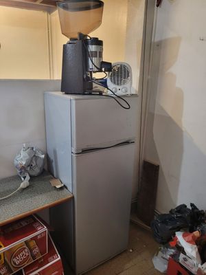 une photo d'une cuisine avec une cafetière posée sur un réfrigérateur