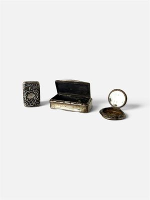 une petite boîte en argent sur laquelle sont fixés un miroir et une bague