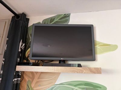a flat screen tv sitting on a shelf in the corner of a room