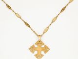 a gold necklace with a cross on a chain