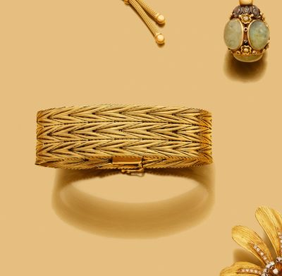 un bracelet, une bague et une broche en or sur fond jaune