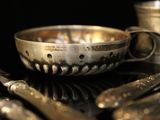 a silver bowl with spoons and forks on a table