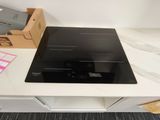 a black stove top sitting on top of a white counter