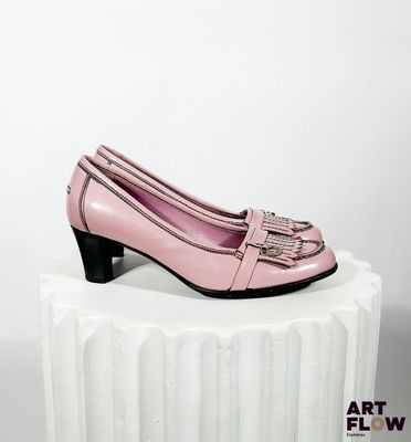 un gros plan sur une paire de chaussures roses posées sur un socle