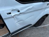 a white van that has been damaged and is parked in a parking lot