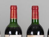 several bottles of wine are lined up in a row on a table