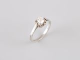 a white gold ring with a diamond in the center