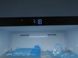 a microwave with plastic bags in it and a digital clock on the door