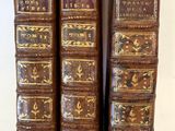trois vieux livres sont empilés sur une table